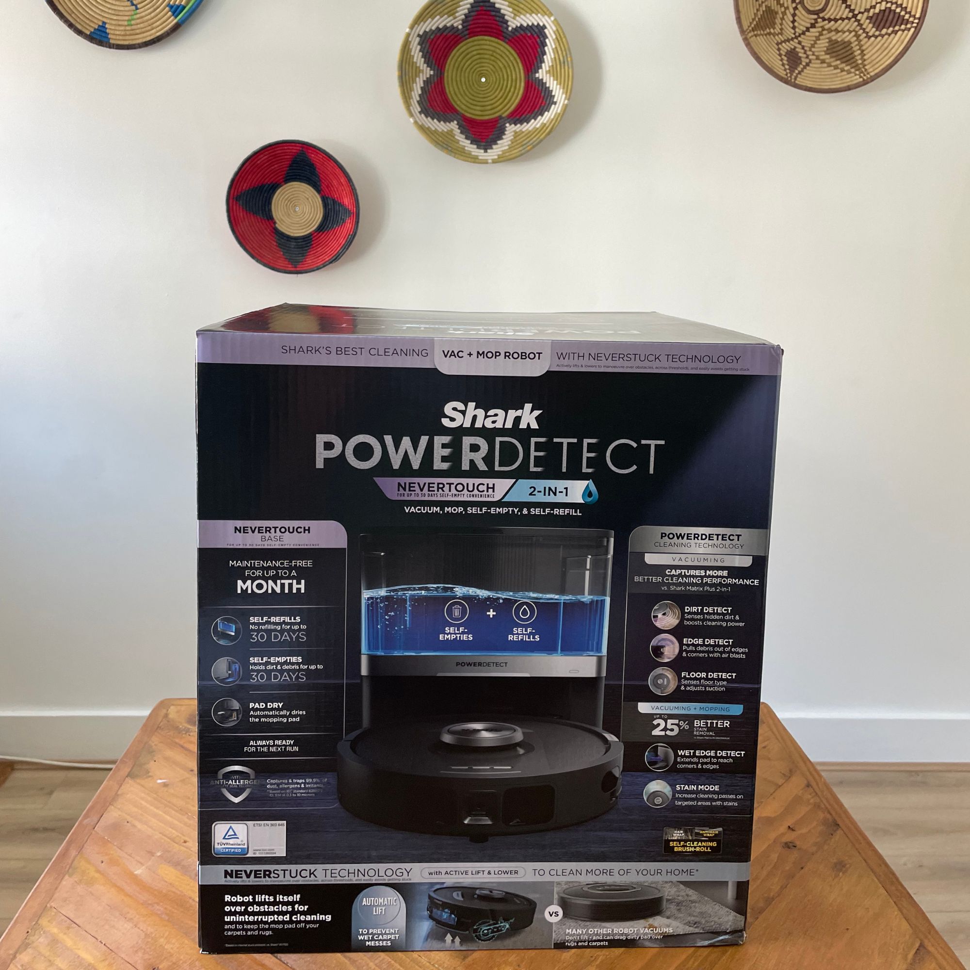 Shark PowerDetect NeverTouch Robot Vacuum and Mop box on a wooden table in front of a white wall