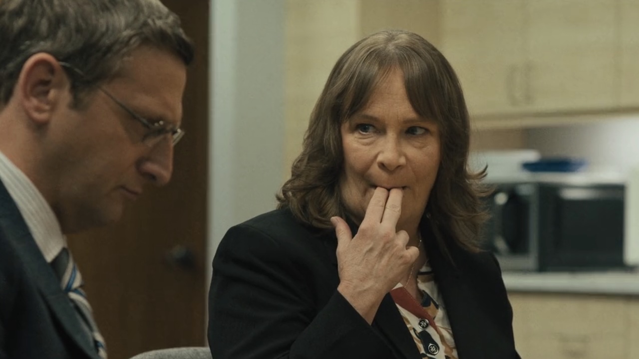 Amanda sucking crumbs off of her fingers while looking at Ron in The Chair Company Episode 6