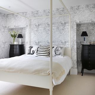 bedroom with printed wall and black chest of drawers