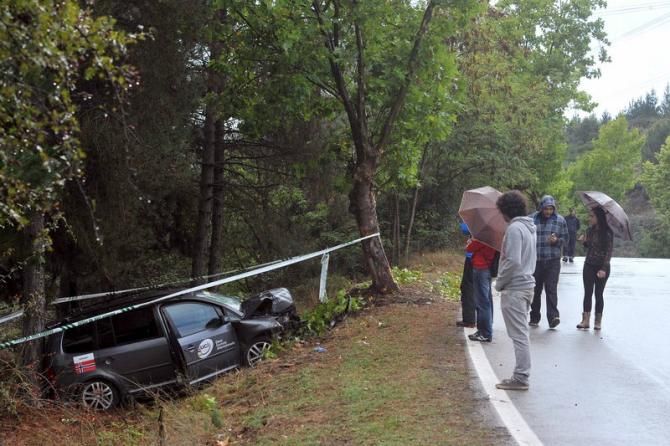 Spectators check out the scene of the Norway team car crash on the course