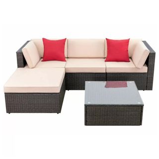 An L-shaped outdoor sofa with cream cushions and a glass topped table