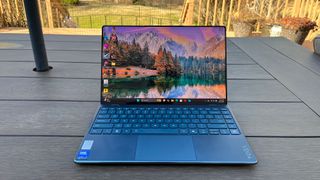 A Lenovo Yoga Slim 9i sitting on a picnic table outside