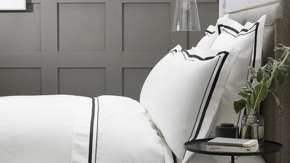 The White Company Cavendish Duvet Cover on bed with black borders on duvet and pillows and grey wall panelling behind