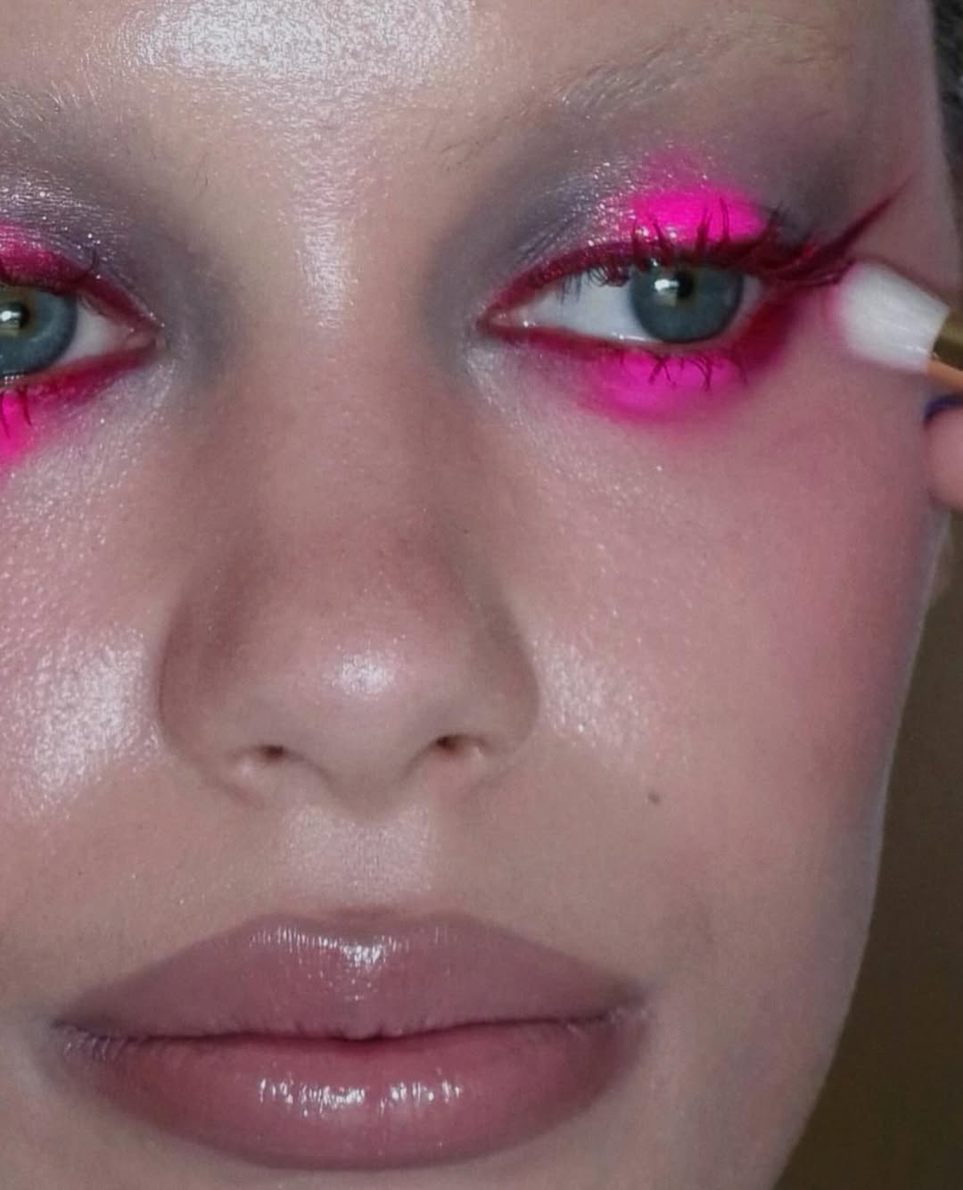 Alexandra French perfects the makeup on a model with heavy highlighter.