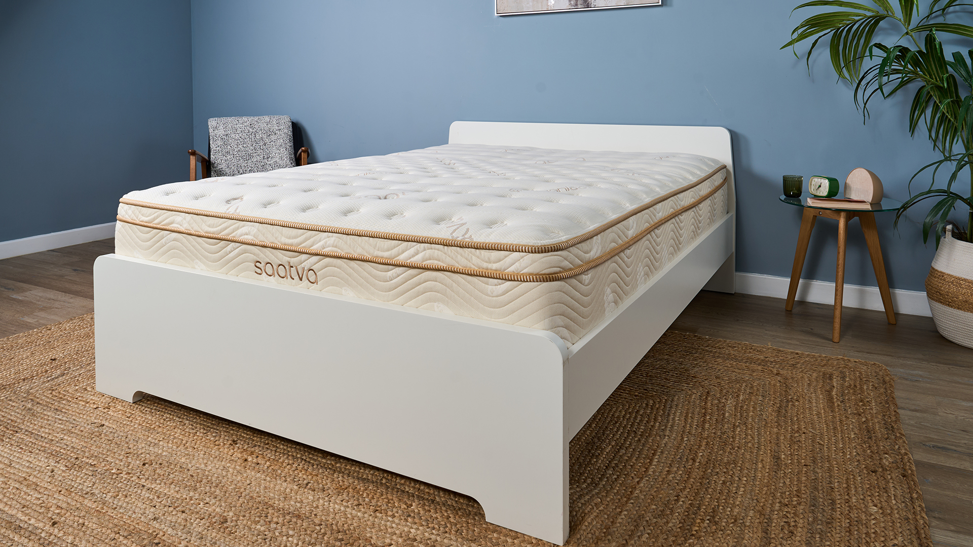 Saatva Classic Luxury Innerspring mattress on a white wooden bed frame in a blue bedroom