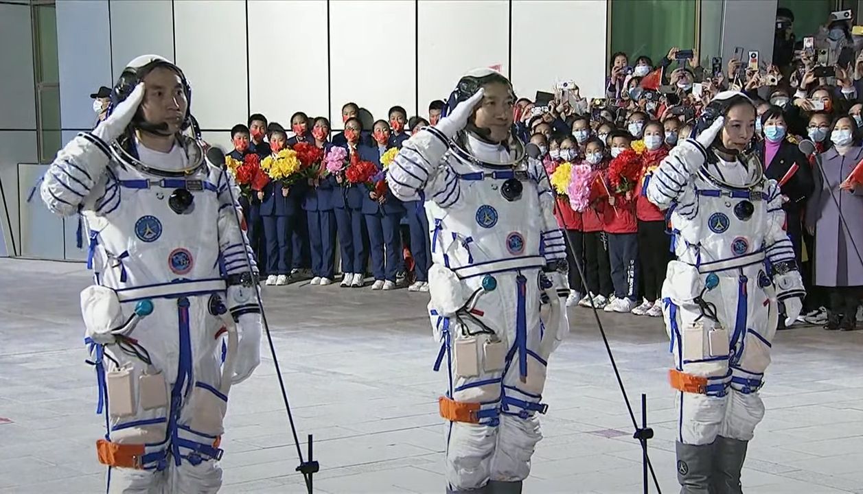 China's Senzhou 13 commander Zhai Zhigang (center) and astronauts Wang Yagping (right) and Ye Guangfu salute as they walk out of their crew quarters ahead of their planned launch from the from Jiuquan Satellite Launch Center on Oct. 16, 2021.