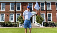 A golfer poses with a flag