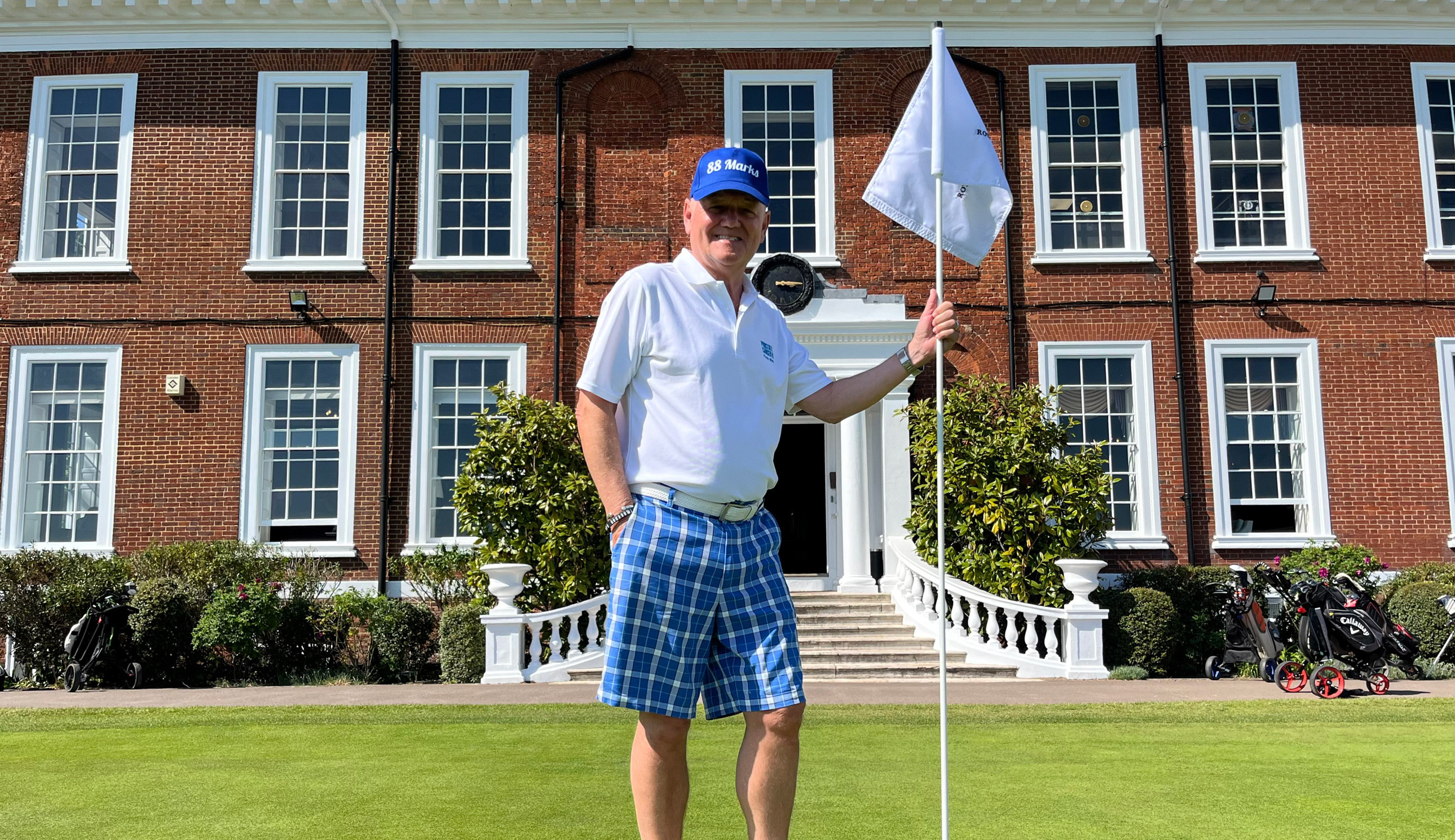 A golfer poses with a flag