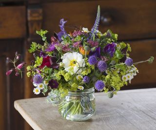 A vase full of cut flowers in mixed colours