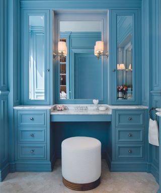 Bathroom dressing room in deep blue with dressing table and mirrors
