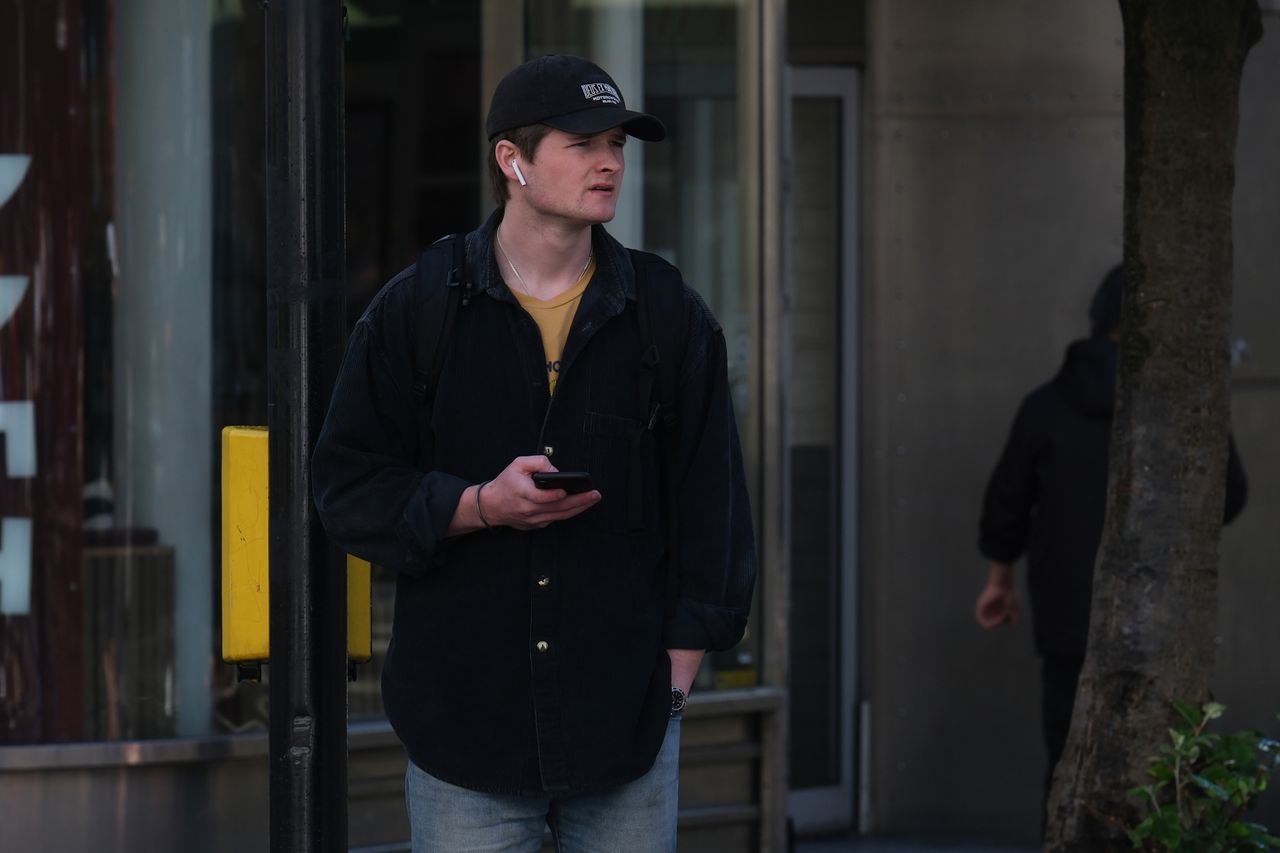 A man waiting at a pedestrian crossing