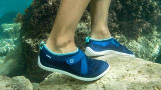 Person's feet wearing Decathlon Aquashoes 500 underwater