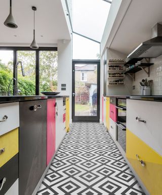 Punchy kitchen scheme with graphic mono floor tiles, and color block cabinets.