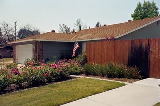 A house with an American flag and flowers in the garden
