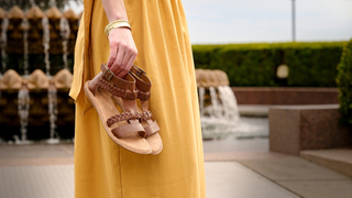 woman holding tan sandals