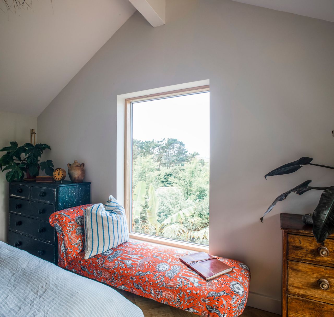 Room with white walls, a vintage chair with cushion and a picture window