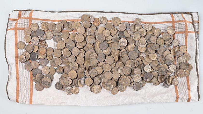 a pile of ancient silver coins on a towel