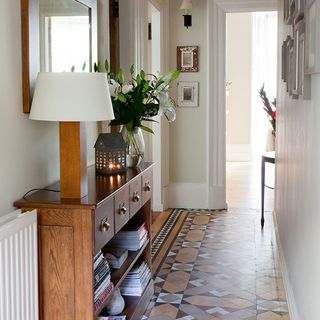 white hallway with tiled flooring and cupboard