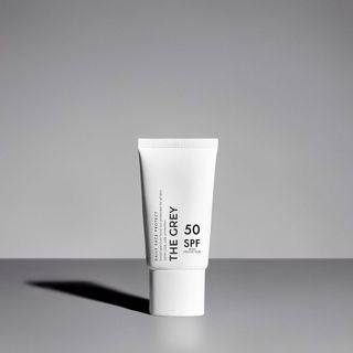 The Grey Daily Face Protect sunscreen in white bottle against grey background