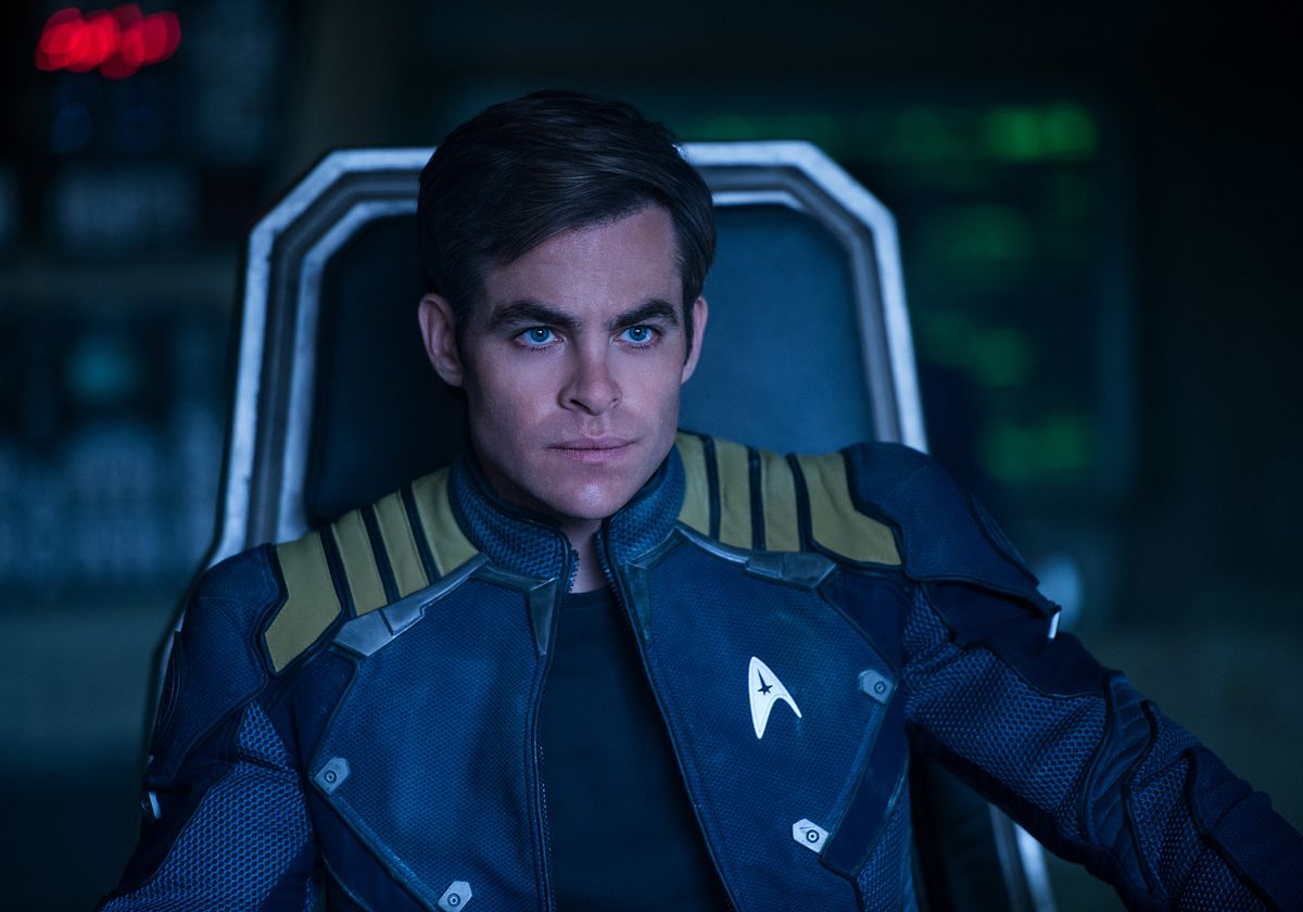 Chris Pine sits and looks thoughtful on the deck of the Starship Enterprise