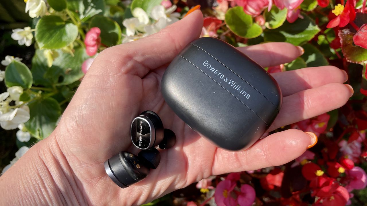 Bowers &amp; Wilkins Pi8 held in a hand, with floral background