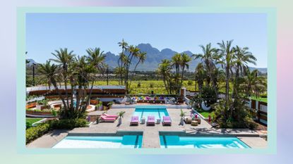 the Winter Love Island 2023 villa in South Africa, where Love Island filmed, showing the villa's pool and the mountain backdrop on a pastel blue template