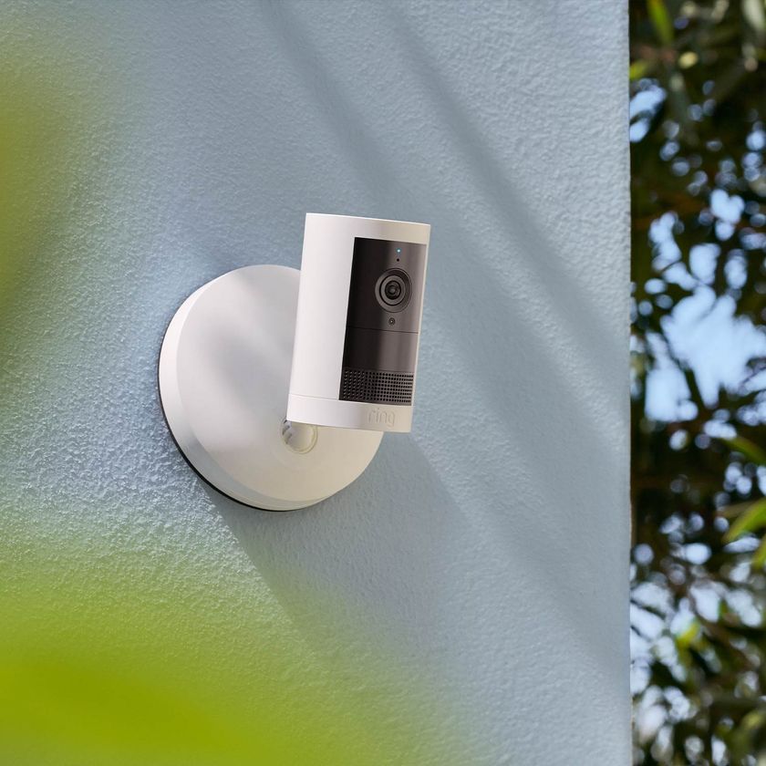 A Ring Outdoor Cam Plus in white attached to an exterior wall