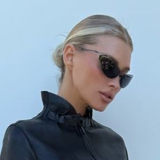 Elsa wears sunglasses and a leather jacket.