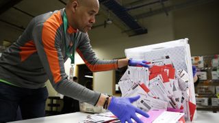 Election worker Erick Moss sorts vote-by-mail ballots for the presidential primary at King County Elections in Renton, Washington, on March 10, 2020. 