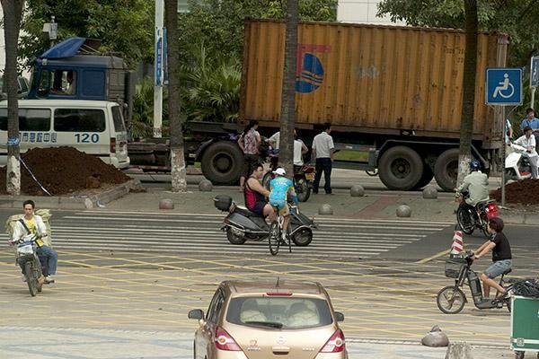 Tour leader, Valentin Iglinskiy (Astana), pedals back to the motel as locals go about their business in Haikou.