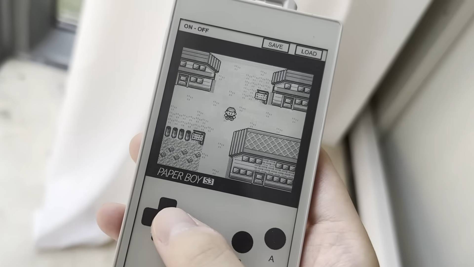 A hand taps the emulated d-pad of an original Game Boy on an ereader device. Pokemon Blue is being played in greyscale.