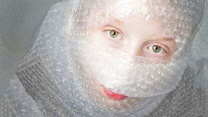 A woman is all wrapped up in bubble wrap.