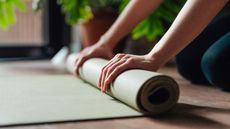 Close-up of female hand folding yoga mat after workout 