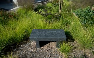 A gray granite bench with writing on it.