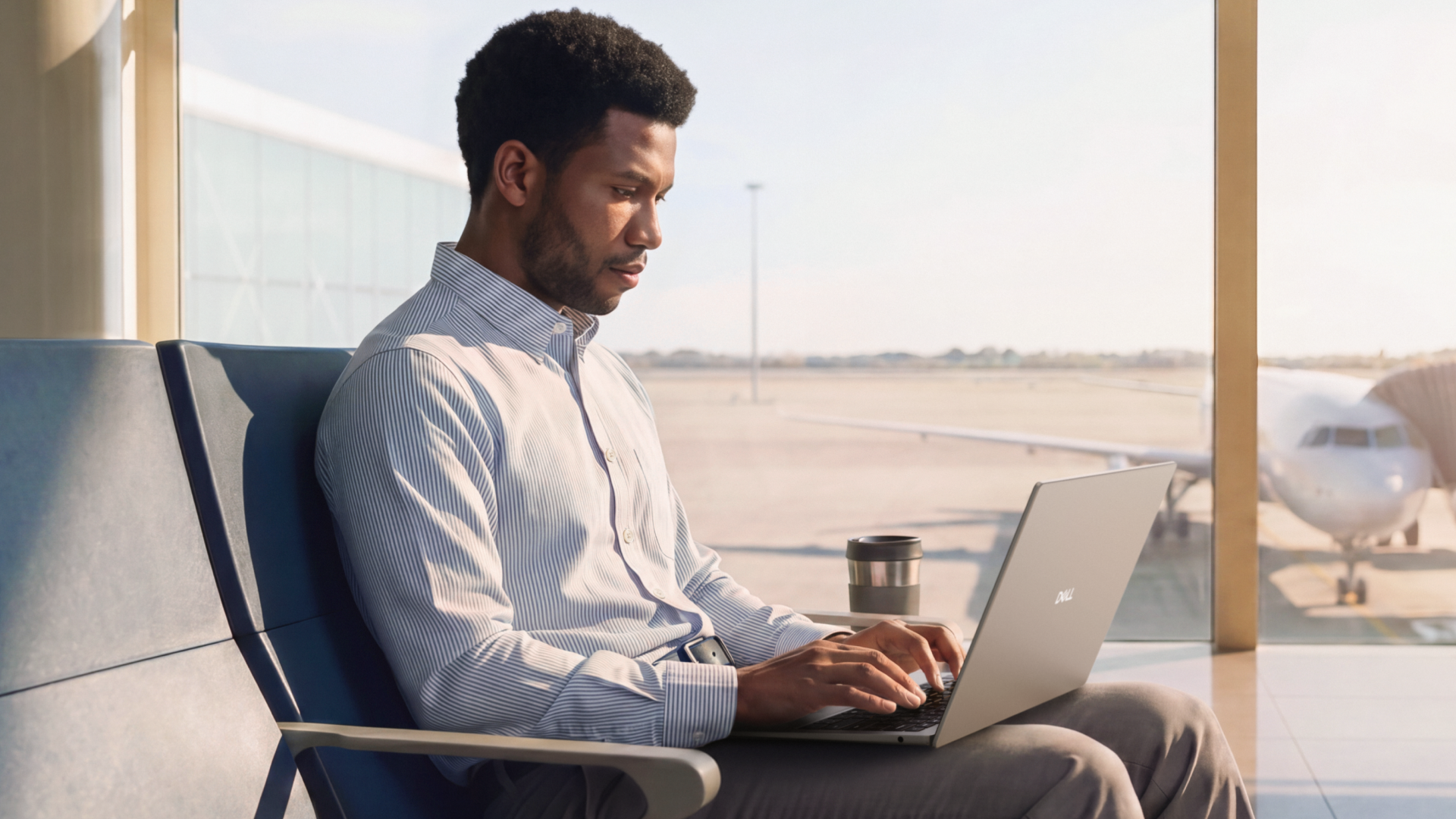 Dell 14S being used by a person in their lap, they are sat in an airport