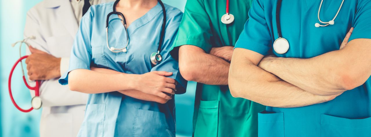 Several health care workers stand in a row.