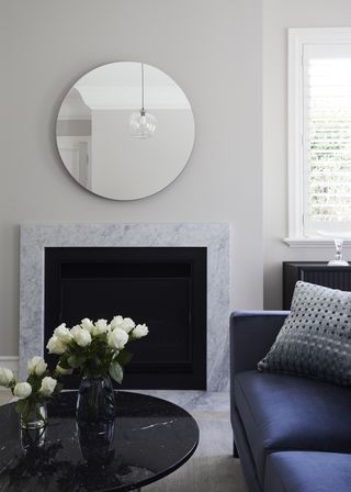 A small living room with a mirror above the fireplace