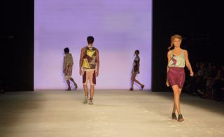 Four models on a runway, displaying sporty cuts mixing with luxe fabrics