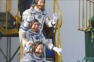 Soyuz MS-21 commander Oleg Artemyev (at bottom) with crewmates Sergey Korsakov and Denis Matveev wave from the launchpad prior to boarding their spacecraft on March 18, 2022.