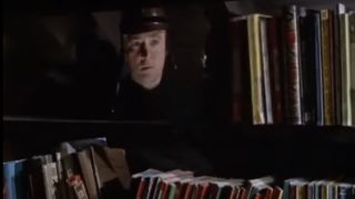 Oskar Werner as Guy Montag looking through a bookshelf in Fahrenheit 451