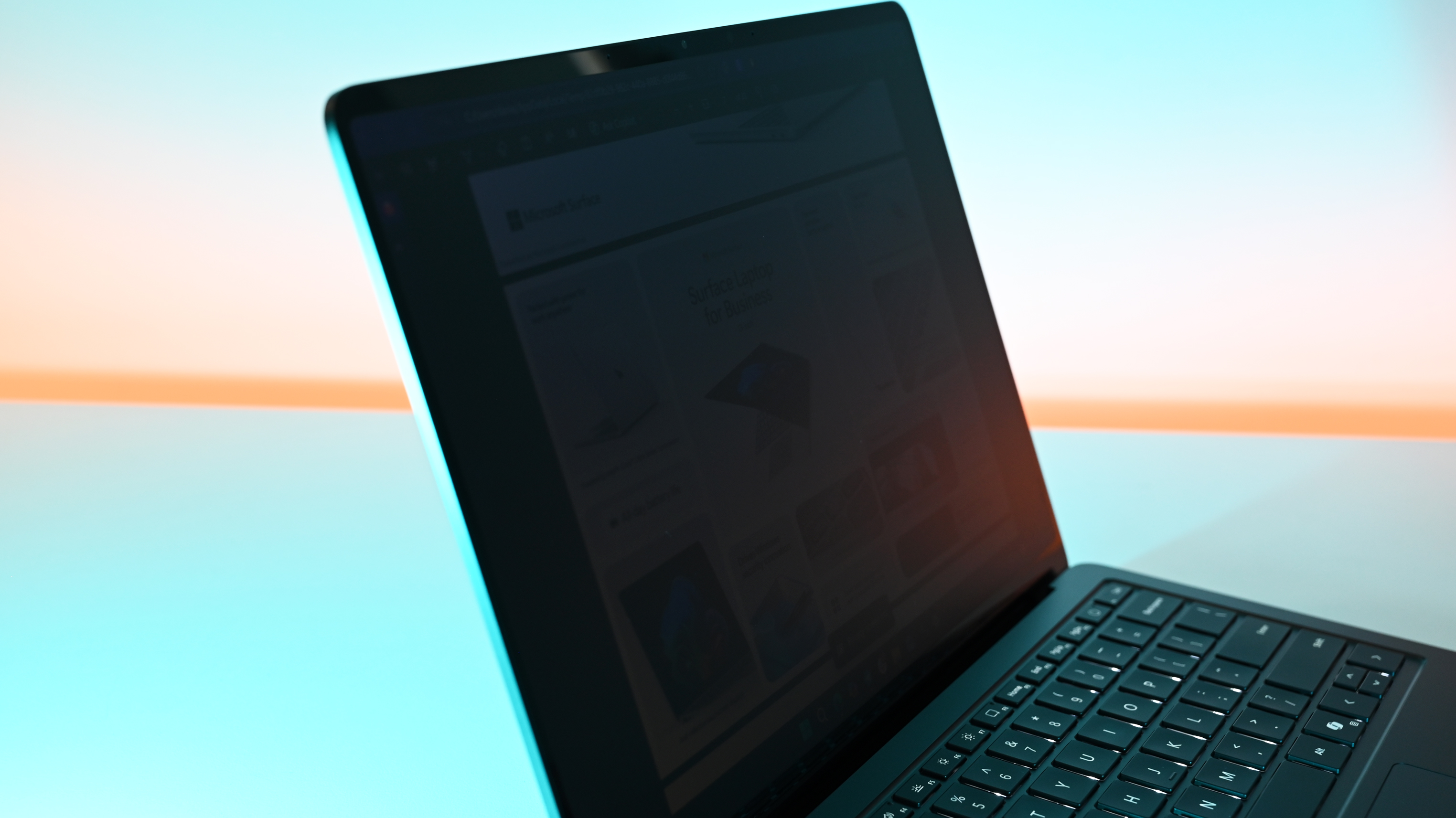 Demonstration of Surface Laptop for Business 8th Edition's privacy screen engaged, making the slightly tilted laptop's display difficult to read due to being so dim.