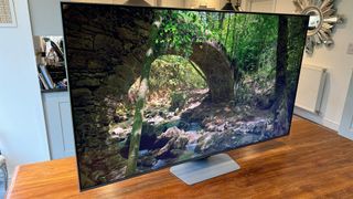 Samsung Q80D 55-inch LED TV on wooden table with forest scene on screen