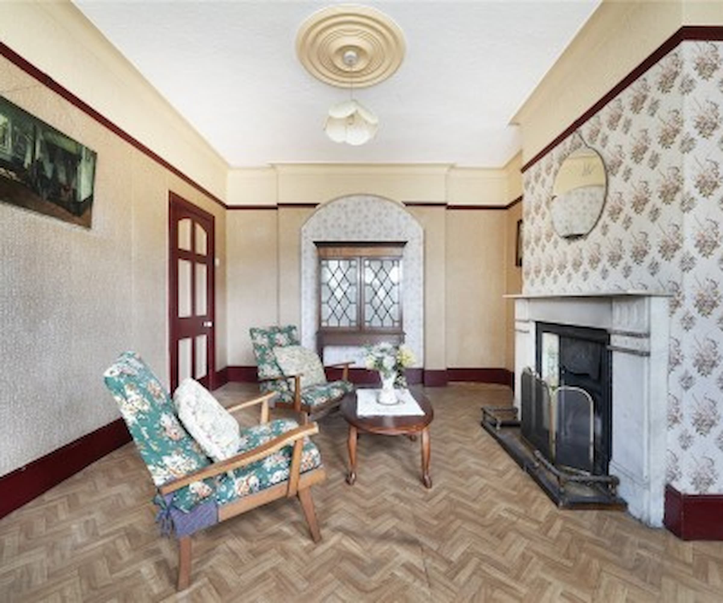 A living room with wooden panelled floor and a fireplace