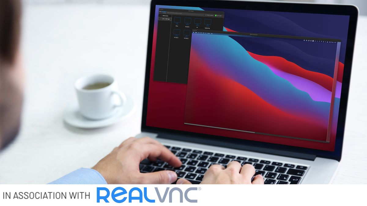 Man sat at desk working on laptop with &amp;#039;In association with RealVNC&amp;#039; text along the bottom