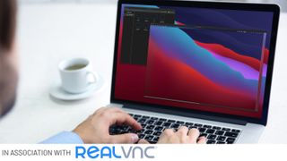 Man sat at desk working on laptop with 'In association with RealVNC' text along the bottom