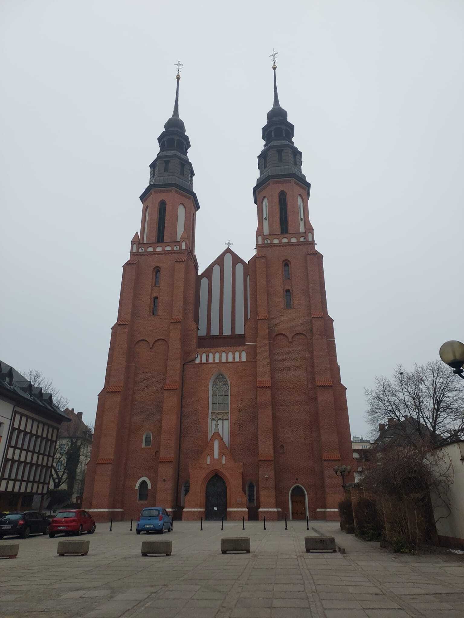 A large brick church with two spires pointed upward.