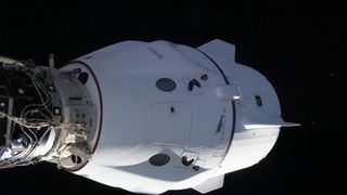 SpaceX's Crew Dragon Freedom spacecraft docked at the International Space Station with black space behind.