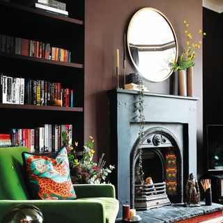 Living room with dark painted fireplace and colourful furniture and furnishings