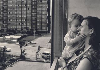 Mother and child in window of flat on French estate