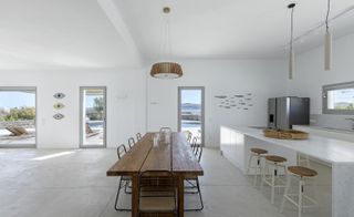 Kitchen area and wooden dining table at KITE House in Greece